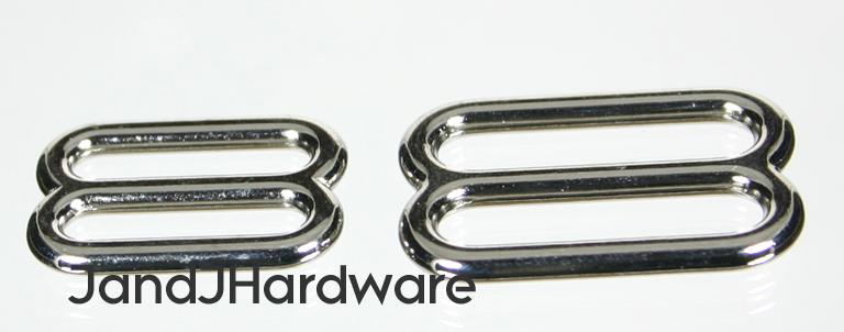 An image of a metal slide, cast with two openings for passing straps along each other.